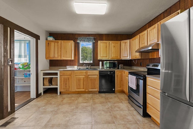 209 Caps Rd, Kalispell, MT 59901 - kitchen with stainless steel appliances, light brown cabinets, under cabinet range hood, light countertops, and light tile patterned floors