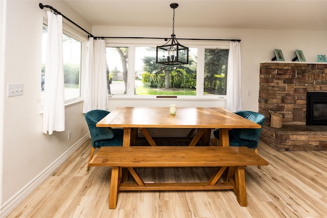3495 Juniper Dr, Helena, MT 59602 - dining space with light wood finished floors, a chandelier, baseboards, and a stone fireplace