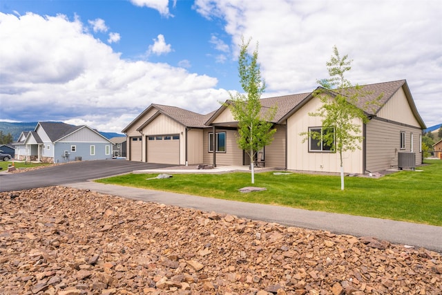 15276 Tyson Way, Frenchtown, MT 59834 - ranch-style home with driveway, an attached garage, cooling unit, and a front lawn