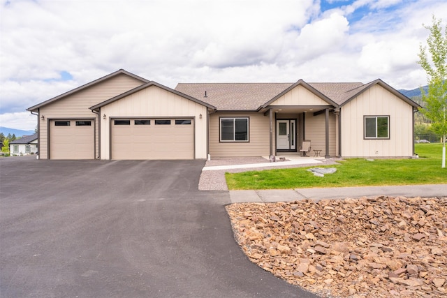15276 Tyson Way, Frenchtown, MT 59834 - ranch-style home featuring a garage, asphalt driveway, a shingled roof, and board and batten siding