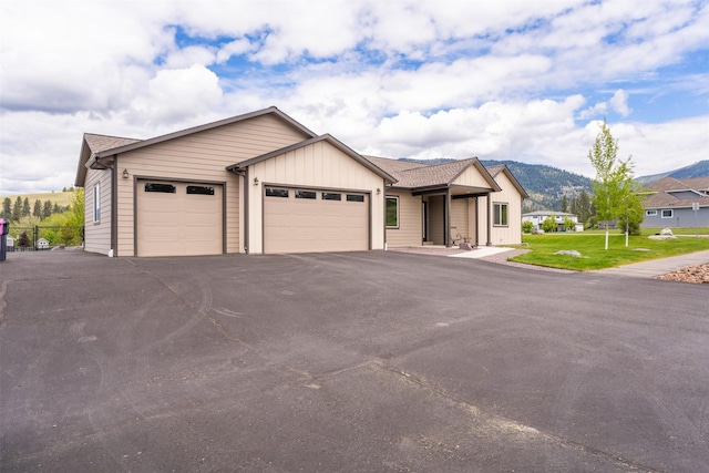 15276 Tyson Way, Frenchtown, MT 59834 - view of front of home featuring an attached garage, board and batten siding, driveway, and a mountain view