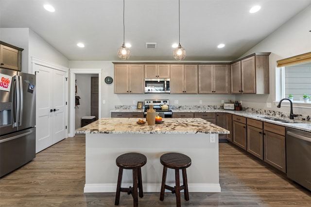 15276 Tyson Way, Frenchtown, MT 59834 - kitchen with stainless steel appliances, a sink, vaulted ceiling, a center island, and light stone countertops