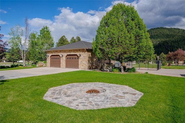 700 Airfield Rd, Libby, MT 59923 - view of front of home featuring a front lawn, concrete driveway, stone siding, and an attached garage