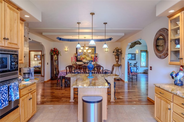 700 Airfield Rd, Libby, MT 59923 - kitchen with arched walkways, a kitchen bar, light brown cabinetry, stainless steel appliances, and baseboards
