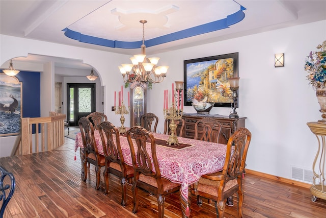 700 Airfield Rd, Libby, MT 59923 - dining room featuring a raised ceiling, a chandelier, wood-type flooring, and baseboards