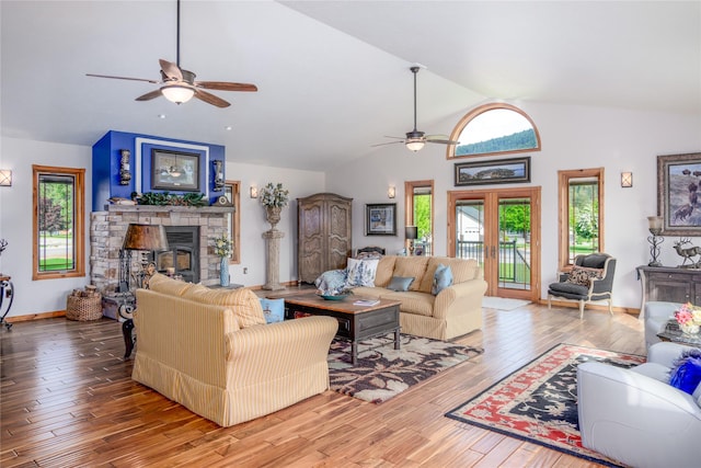 700 Airfield Rd, Libby, MT 59923 - living area featuring lofted ceiling, ceiling fan, hardwood / wood-style floors, a stone fireplace, and baseboards
