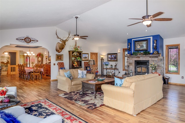 700 Airfield Rd, Libby, MT 59923 - living area with a ceiling fan, arched walkways, lofted ceiling, wood finished floors, and a stone fireplace