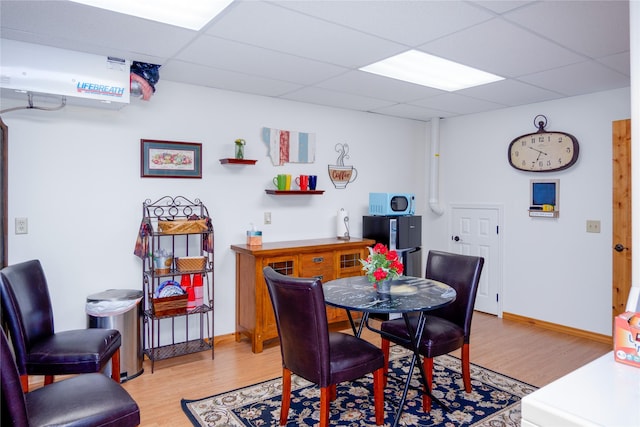 700 Airfield Rd, Libby, MT 59923 - dining area featuring light wood-type flooring, a paneled ceiling, and baseboards