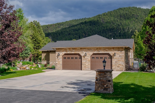 700 Airfield Rd, Libby, MT 59923 - view of front of property featuring a view of trees, stone siding, a mountain view, and concrete driveway
