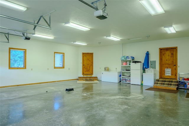700 Airfield Rd, Libby, MT 59923 - garage with freestanding refrigerator, a garage door opener, electric panel, and fridge