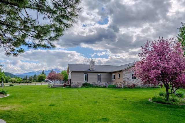 700 Airfield Rd, Libby, MT 59923 - rear view of house with a chimney, stone siding, and a deck with mountain view