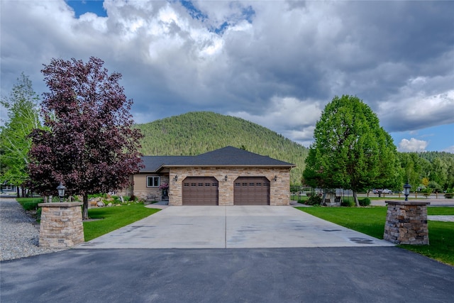 700 Airfield Rd, Libby, MT 59923 - view of front of house featuring an attached garage, a mountain view, driveway, and a front lawn