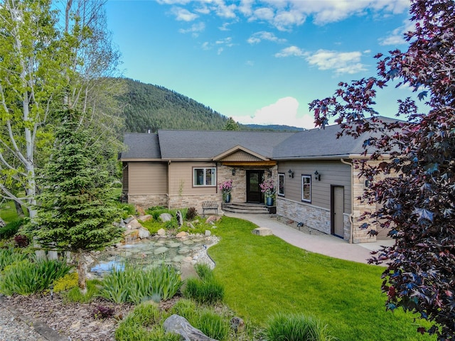 700 Airfield Rd, Libby, MT 59923 - ranch-style home with stone siding, a mountain view, and a front yard
