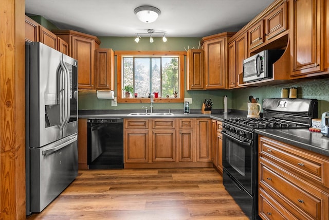 33893 Redgate Dr, Bigfork, MT 59911 - kitchen featuring black appliances, dark countertops, and brown cabinetry