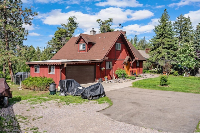 33893 Redgate Dr, Bigfork, MT 59911 - view of front facade featuring driveway, a chimney, and a front lawn