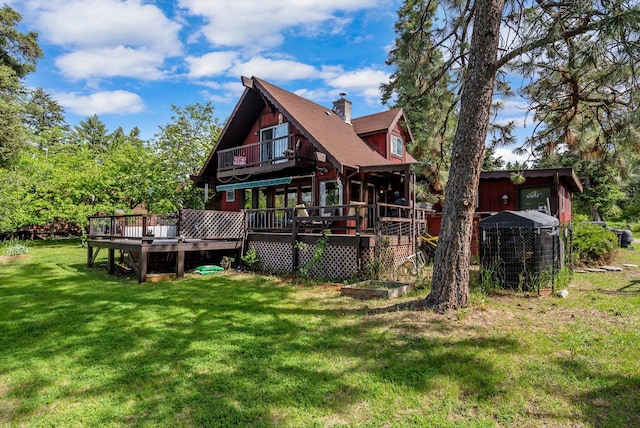 33893 Redgate Dr, Bigfork, MT 59911 - back of house featuring a lawn, a chimney, and a wooden deck