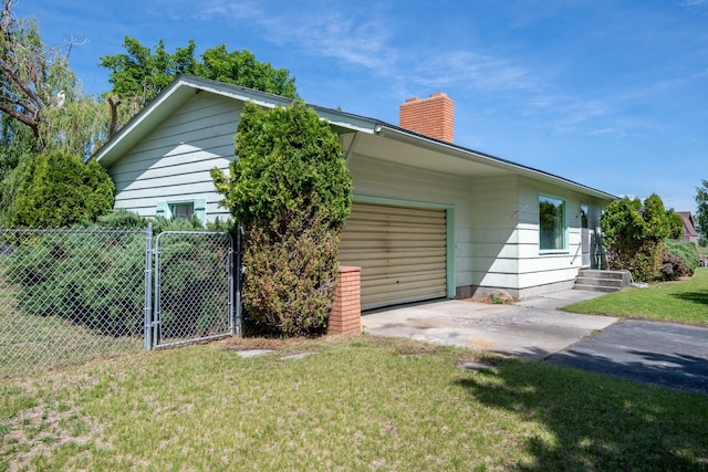 2015 Tower St, Missoula, MT 59804 - view of home's exterior with a chimney, an attached garage, and concrete driveway