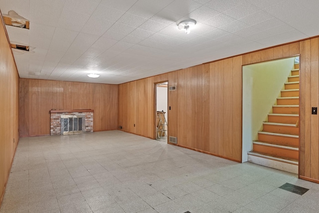 2015 Tower St, Missoula, MT 59804 - unfurnished living room with a fireplace, tile patterned floors, stairway, wood walls, and baseboards