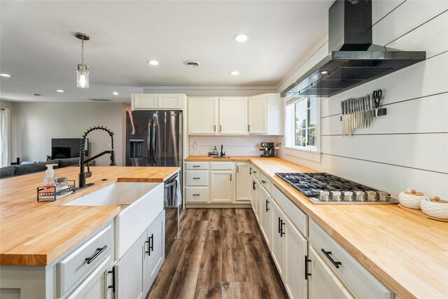 1296 Bighorn Rd, Helena, MT 59602 - kitchen featuring butcher block countertops, stainless steel appliances, wall chimney exhaust hood, white cabinetry, and dark wood finished floors