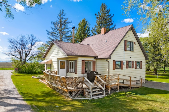 151 6th Ln NE, Fairfield, MT 59436 - back of property featuring roof with shingles, a lawn, a chimney, and a wooden deck