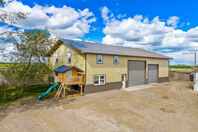 151 6th Ln NE, Fairfield, MT 59436 - back of property with metal roof, driveway, a garage, and a playground