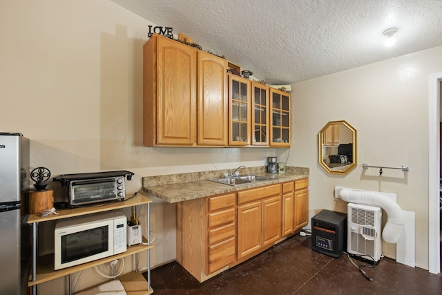 151 6th Ln NE, Fairfield, MT 59436 - kitchen featuring white microwave, a sink, freestanding refrigerator, glass insert cabinets, and a textured ceiling
