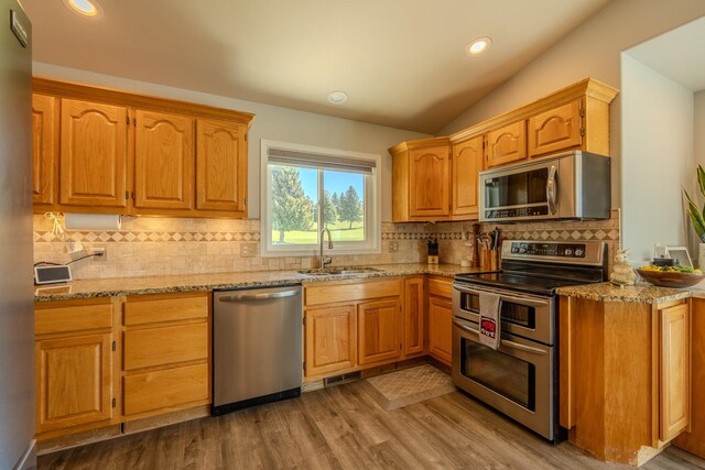 4134 Fox Ridge Dr, Helena, MT 59602 - kitchen featuring appliances with stainless steel finishes, a sink, light stone counters, decorative backsplash, and recessed lighting