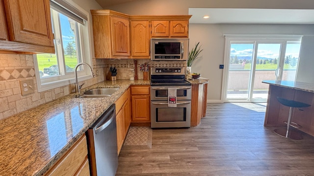 4134 Fox Ridge Dr, Helena, MT 59602 - kitchen with appliances with stainless steel finishes, a sink, light stone counters, light wood-style floors, and recessed lighting