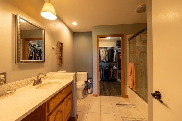 4134 Fox Ridge Dr, Helena, MT 59602 - bathroom featuring toilet, vanity, tile patterned flooring, a spacious closet, and shower / bath combination with glass door