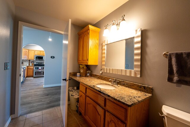 4134 Fox Ridge Dr, Helena, MT 59602 - bathroom with vanity, toilet, tile patterned floors, baseboards, and backsplash
