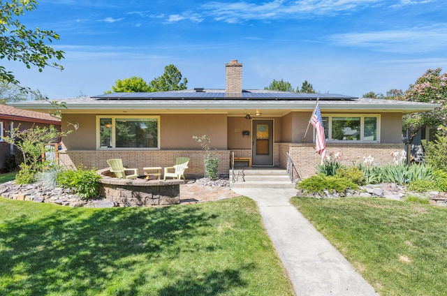 630 Woodworth Ave, Missoula, MT 59801 - ranch-style home featuring brick siding, a front yard, a chimney, and solar panels