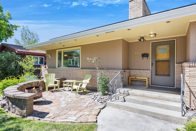 630 Woodworth Ave, Missoula, MT 59801 - doorway to property featuring brick siding, a chimney, and a patio