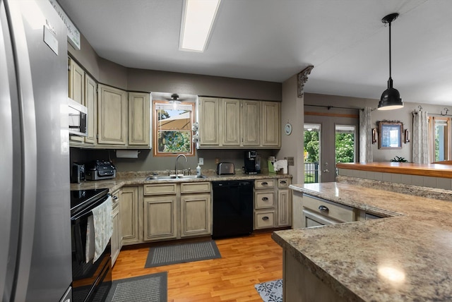 36 Winchester St, Kalispell, MT 59901 - kitchen with appliances with stainless steel finishes, a sink, light wood-type flooring, hanging light fixtures, and cream cabinetry
