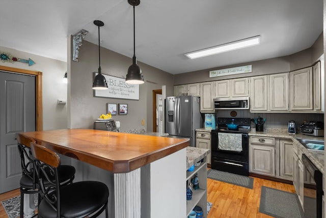 36 Winchester St, Kalispell, MT 59901 - kitchen featuring black appliances, light wood-style floors, a kitchen bar, pendant lighting, and open shelves