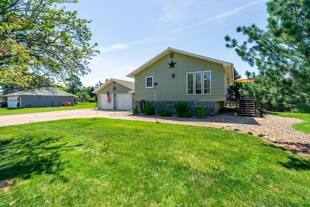 36 Winchester St, Kalispell, MT 59901 - view of front facade featuring a front yard, a garage, stairs, and stone siding