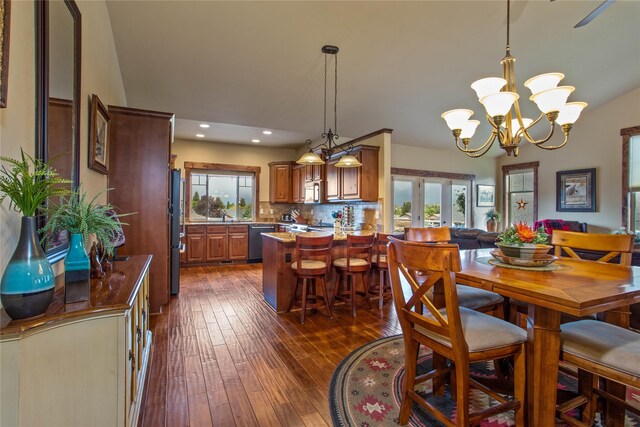 309 Timberwolf Dr, Polson, MT 59860 - dining space featuring a chandelier, dark wood finished floors, arched walkways, high vaulted ceiling, and baseboards