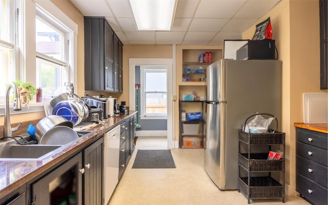 831 Hastings Ave, Missoula, MT 59801 - kitchen featuring freestanding refrigerator, a paneled ceiling, a sink, dishwasher, and beverage cooler