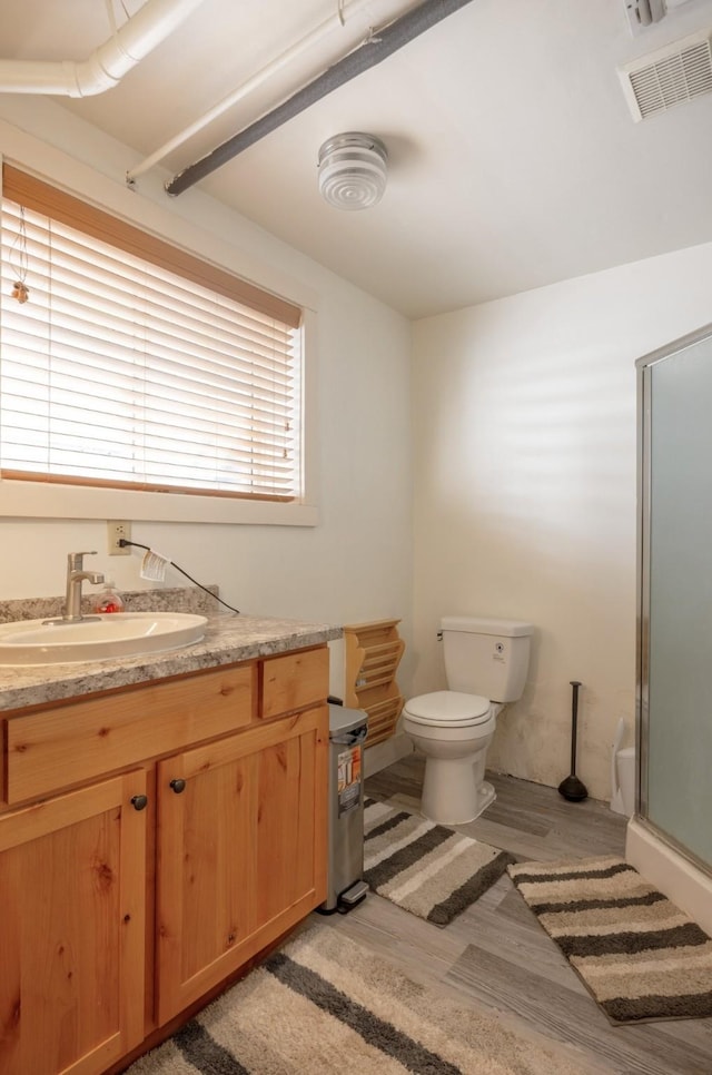 831 Hastings Ave, Missoula, MT 59801 - full bath with wood finished floors, a shower stall, toilet, and vanity