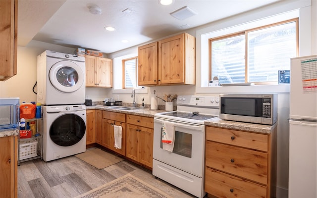 831 Hastings Ave, Missoula, MT 59801 - kitchen with white appliances, a sink, estacked washer and dryer, light brown cabinets, and recessed lighting