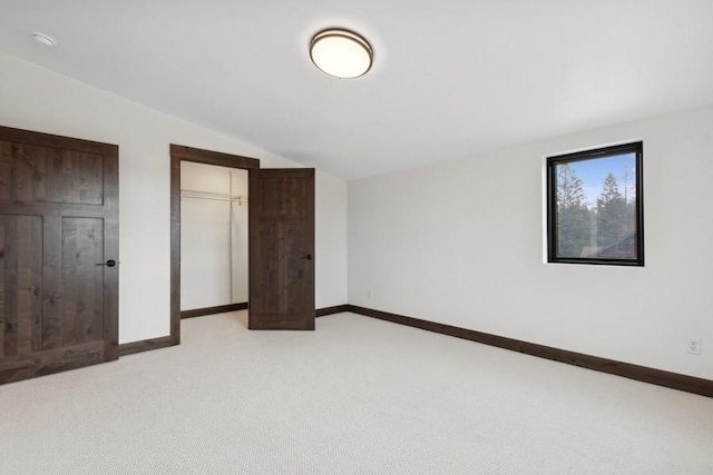 1942 Whitefish Ave, Whitefish, MT 59937 - unfurnished bedroom with vaulted ceiling, light colored carpet, and a closet