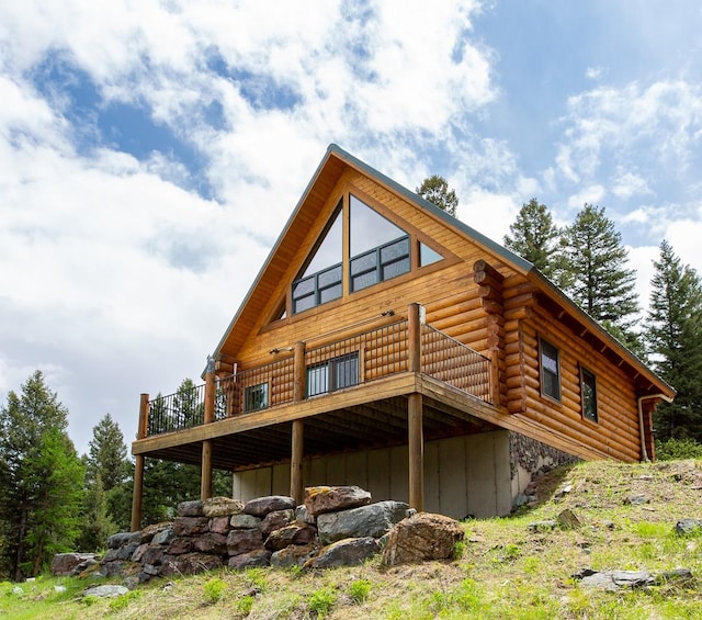589 Summit Dr, Seeley Lake, MT 59868 - back of property with log exterior and a deck