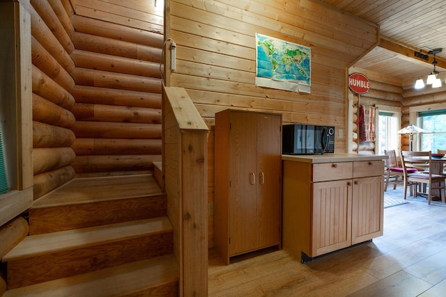 589 Summit Dr, Seeley Lake, MT 59868 - kitchen featuring black microwave, wooden ceiling, rustic walls, light wood-type flooring, and light countertops