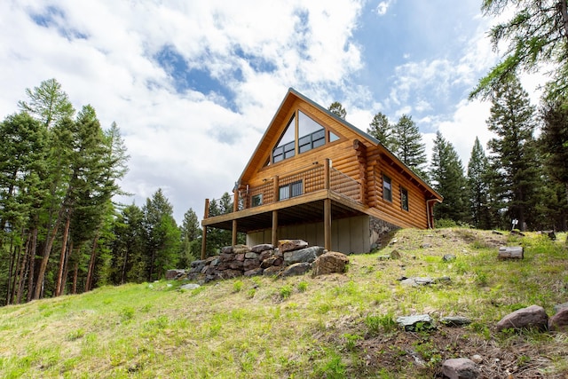 589 Summit Dr, Seeley Lake, MT 59868 - back of house featuring log exterior, a wooden deck, and board and batten siding