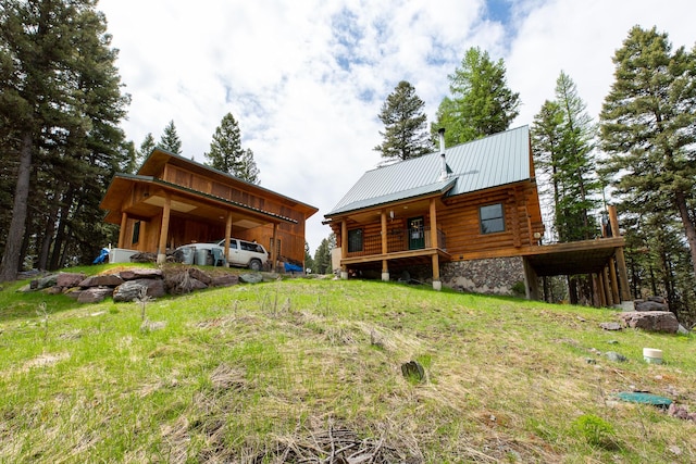 589 Summit Dr, Seeley Lake, MT 59868 - back of property with log siding, a metal roof, a standing seam roof, and a carport