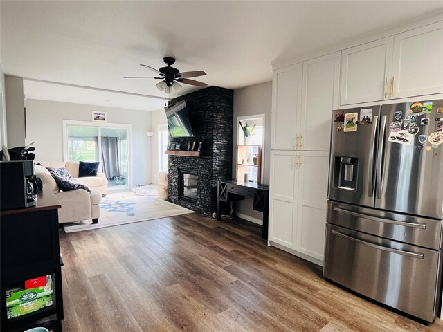 502 Illinois Ave, Valier, MT 59486 - living area featuring ceiling fan, a stone fireplace, and light wood-style flooring