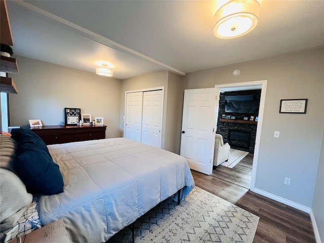 502 Illinois Ave, Valier, MT 59486 - bedroom with wood finished floors, baseboards, a fireplace, and a closet