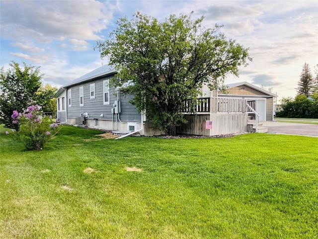 502 Illinois Ave, Valier, MT 59486 - view of side of home featuring a lawn, central air condition unit, and a wooden deck