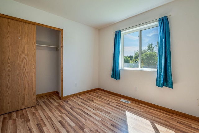 144 Beargrass Ln, Kalispell, MT 59901 - unfurnished bedroom with wood finished floors, baseboards, and a closet