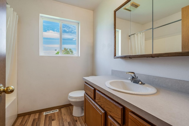 144 Beargrass Ln, Kalispell, MT 59901 - bathroom with vanity, wood finished floors, toilet, and a shower with shower curtain