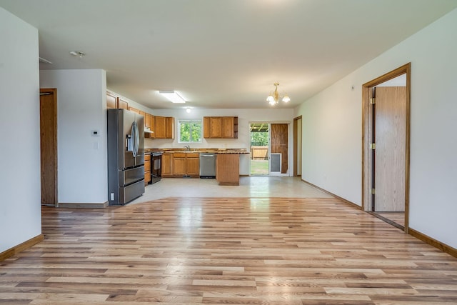 144 Beargrass Ln, Kalispell, MT 59901 - kitchen featuring stainless steel appliances, a chandelier, light wood finished floors, and brown cabinets
